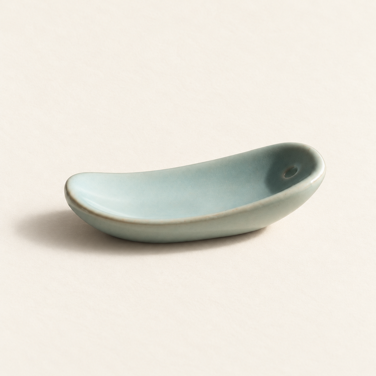 Side view showing the curved profile of the celadon ceramic incense holder