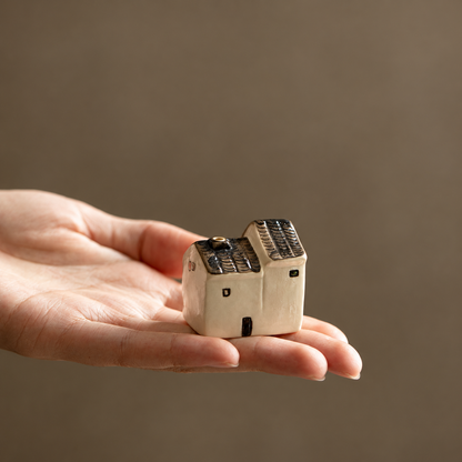 Short ceramic house incense holder resting on a hand to show its compact size