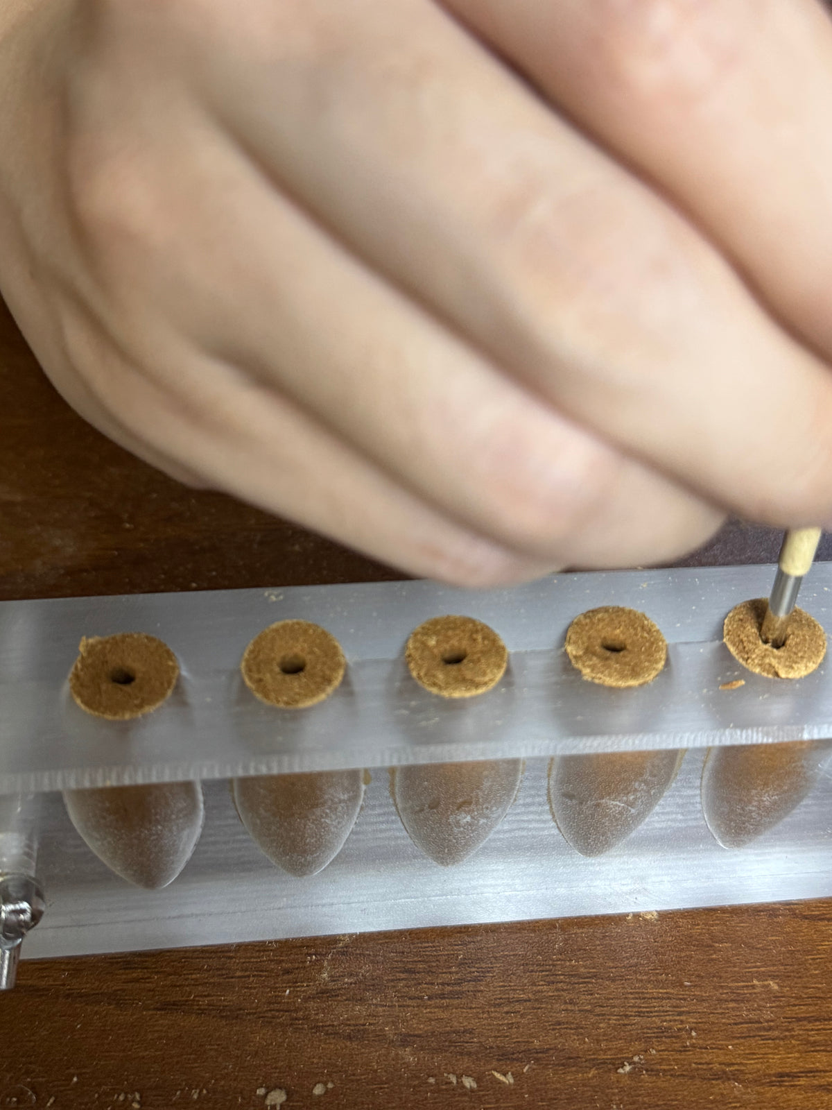 Making the central holes of backflow incense cones in a mould