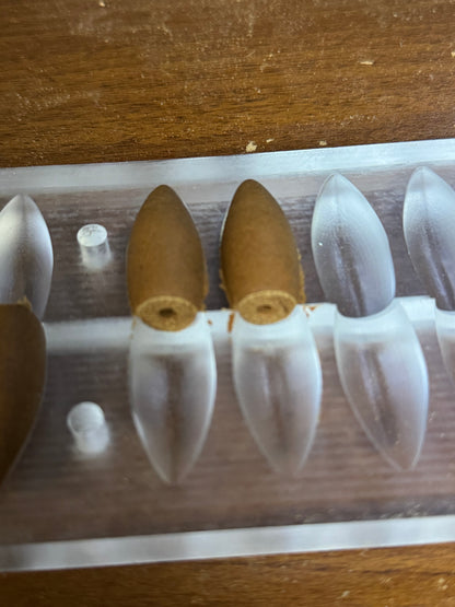 Close-up of backflow incense cones and central openings in a mould