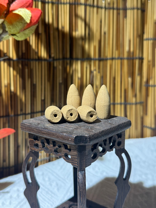 Handmade backflow incense cones on a carved wooden display stand